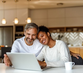 couple looking at a laptop while smiling